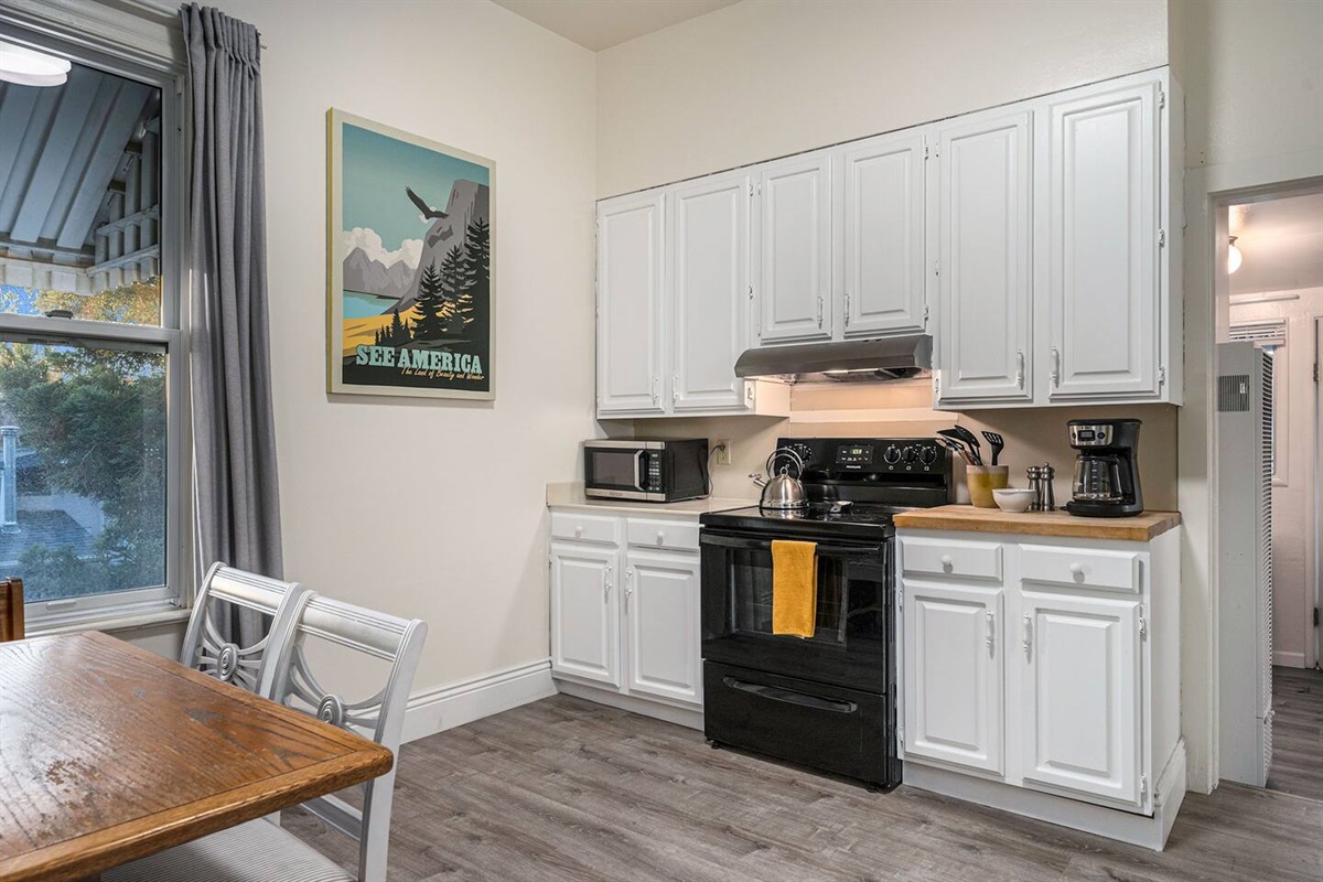 Fully stocked kitchen with stove, oven, dishwasher, refrigerator, microwave, coffee maker, pressure cooker, toaster oven, garbage disposal, and cute booth dining area.