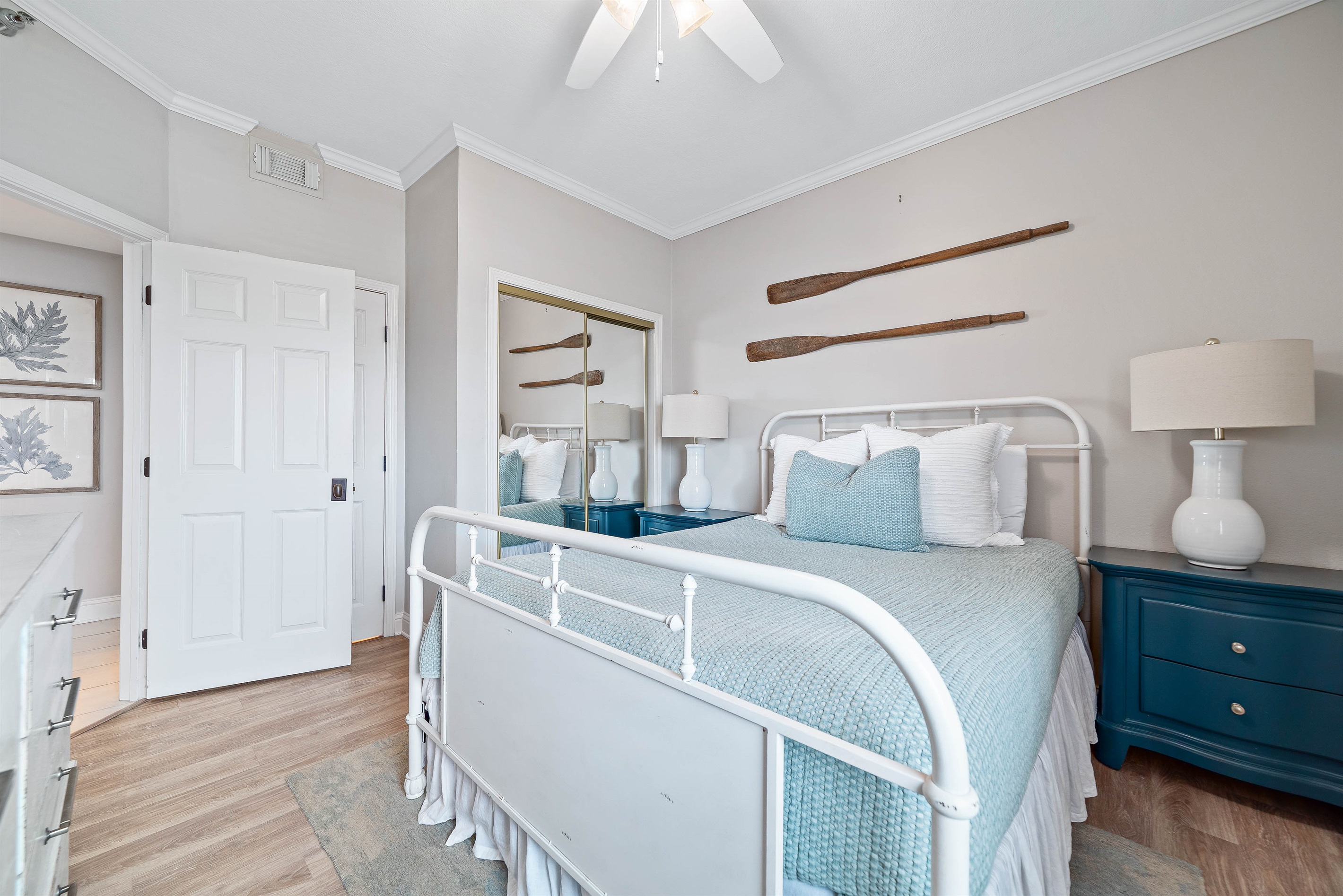 Comfortable queen -size bed with crisp white linens, flanked by matching nightstands and lamps, providing a cozy and inviting space.