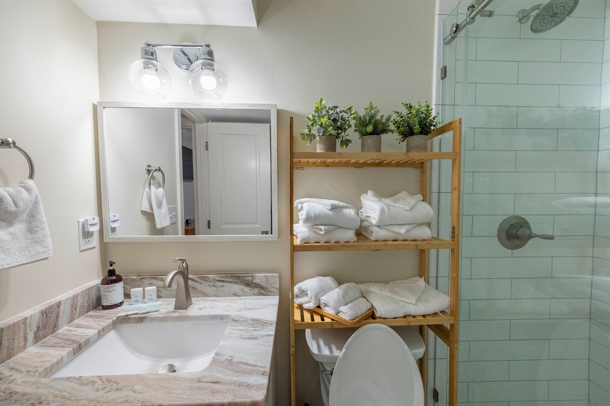 Enjoy this modern, fully equipped full bath on the first floor, complete with fresh towels and essentials!