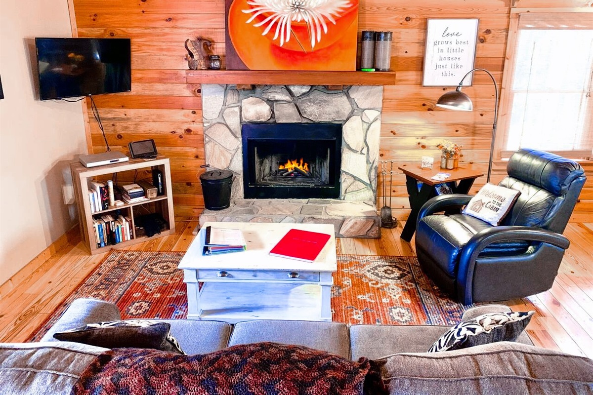 Cozy Living Area with plenty of seating including a recliner, Stone Fireplace & Smart TV