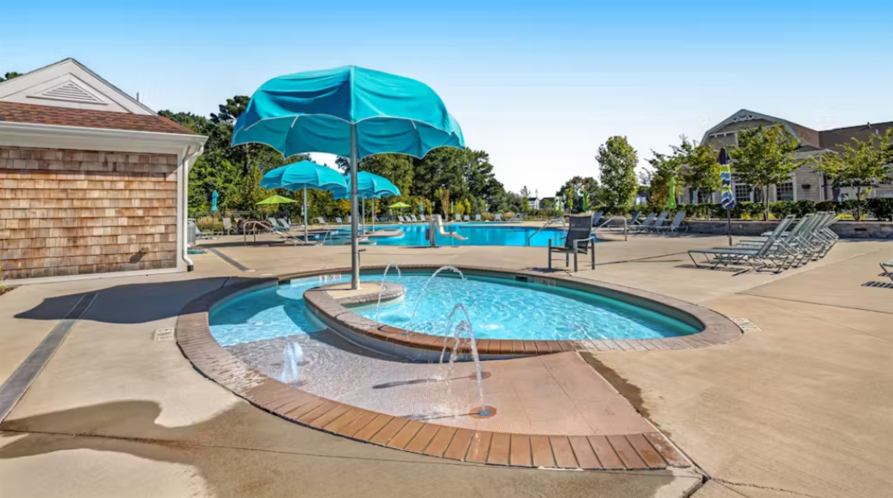 Shallow kids’ pool with playful fountains and umbrella shade—perfect for little ones to splash safely.