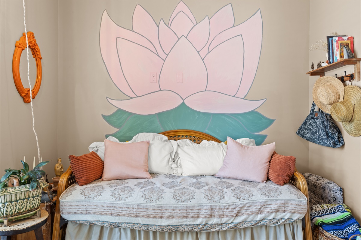 Boho‑inspired daybed room with hand‑painted lotus mural — a serene space to relax.