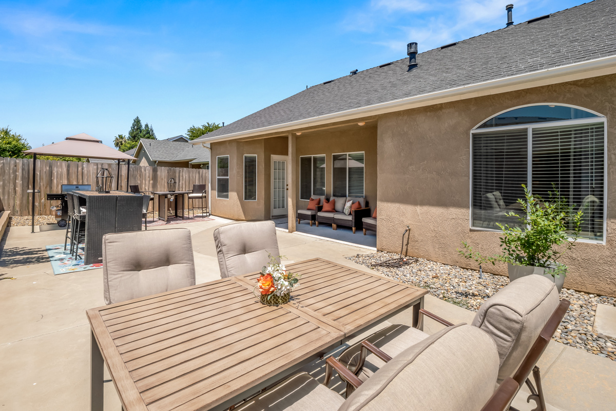 The spacious backyard offers everything you need for outdoor enjoyment, including dining areas, a BBQ grill, comfortable lounge seating, and fun yard games for guests of all ages.