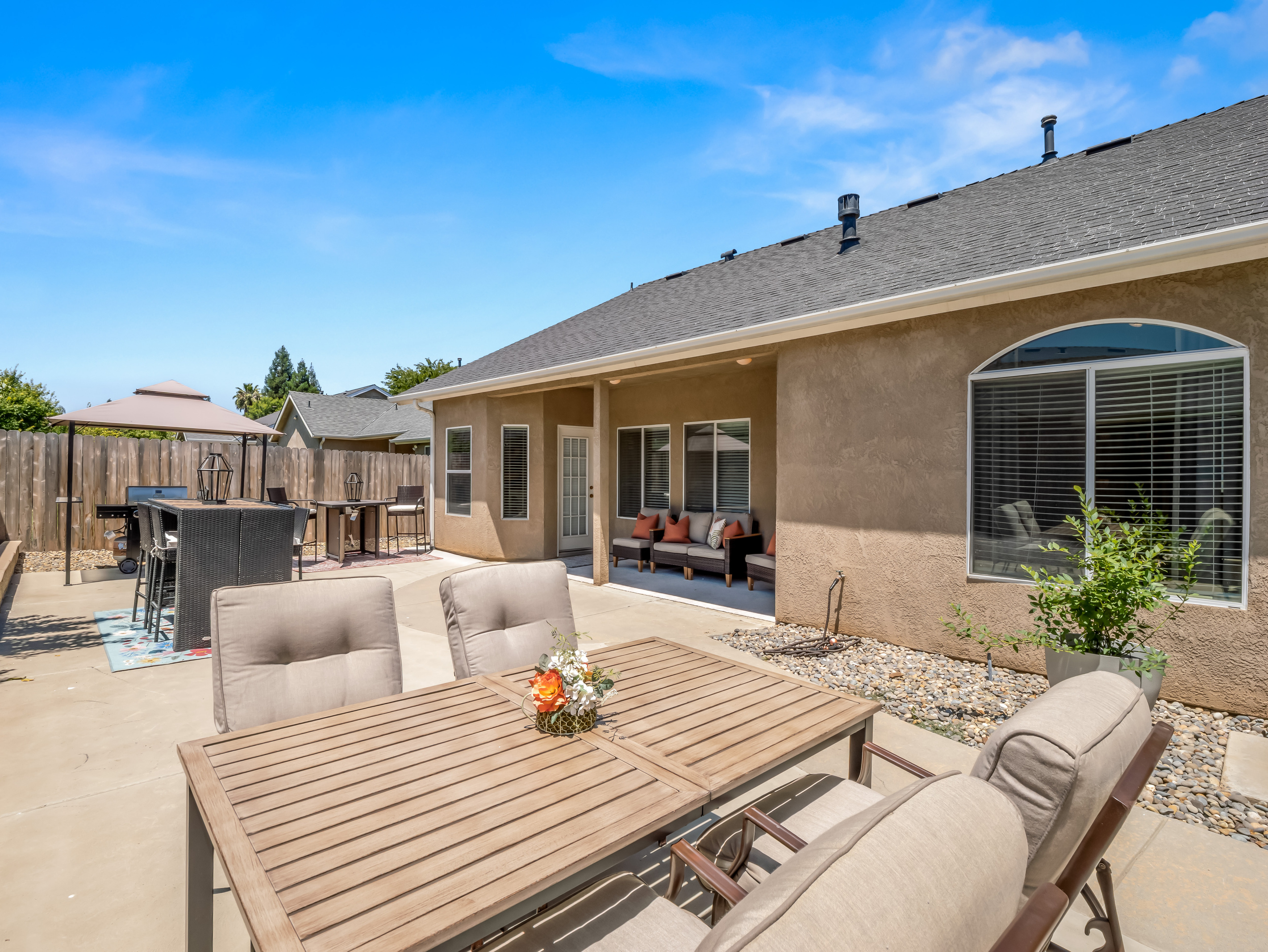 The spacious backyard offers everything you need for outdoor enjoyment, including dining areas, a BBQ grill, comfortable lounge seating, and fun yard games for guests of all ages.