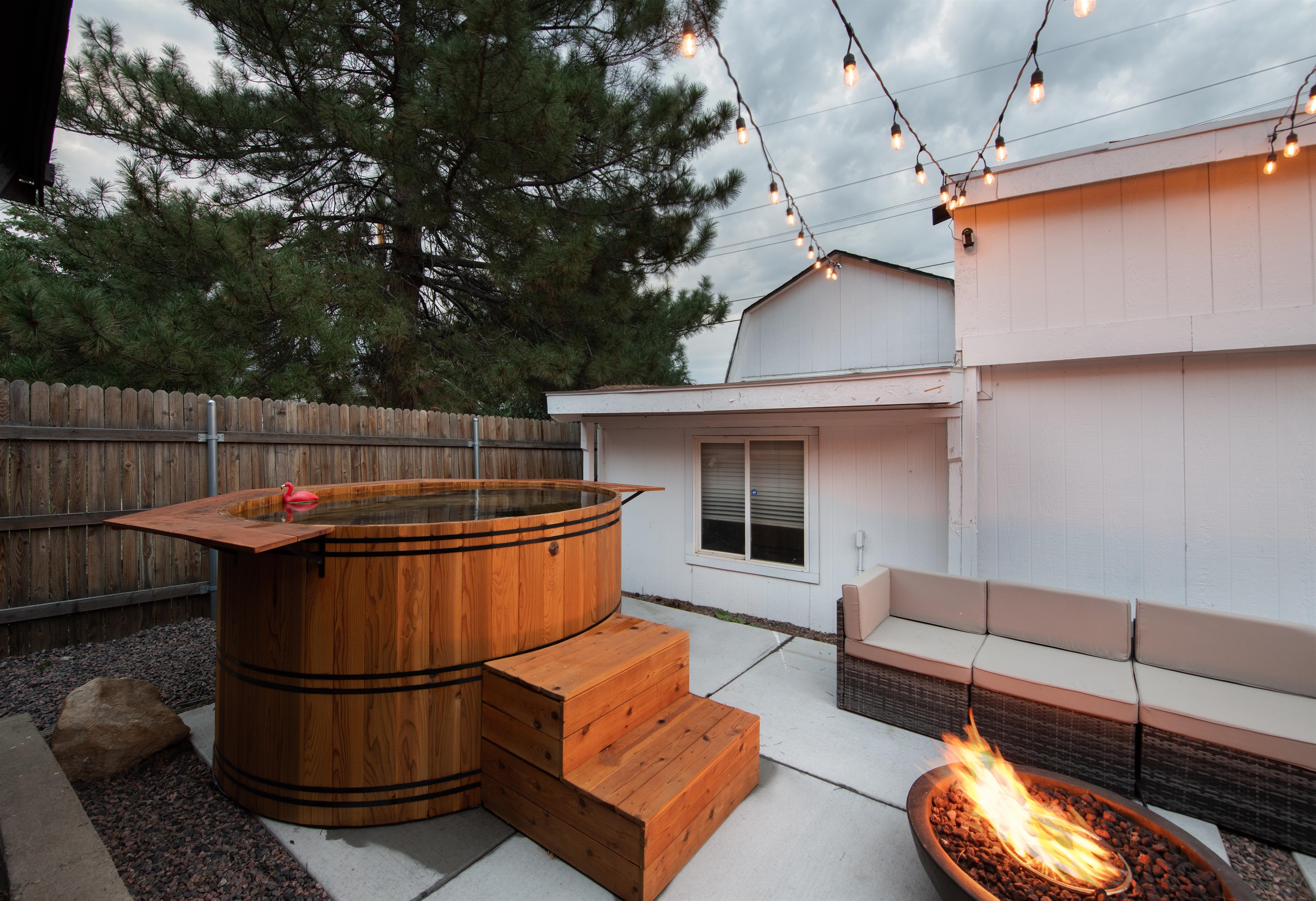 Cedarwood soaking hot tub in front of backyard ADU (in white).