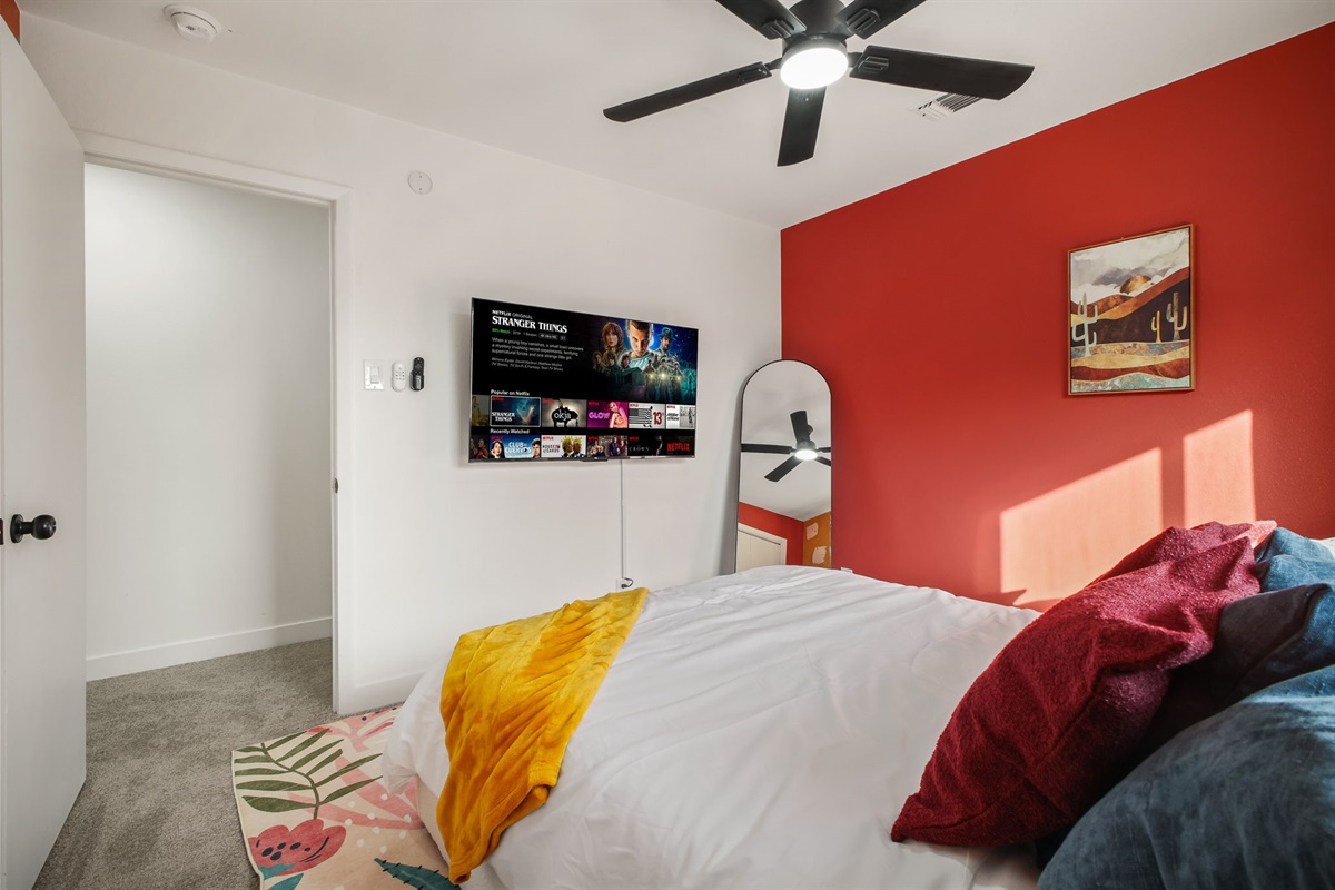 Bedroom 3: Terracotta-red walls and artistic décor reflect modern Southwest charm.