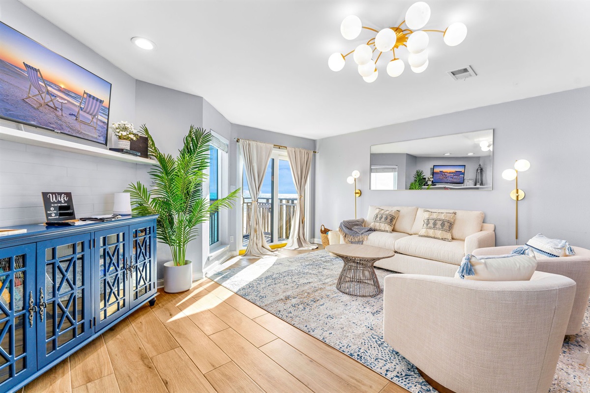The living room features a sofa that transforms into a comfortable Queen Sleeper, complemented by two stylish swivel chairs.