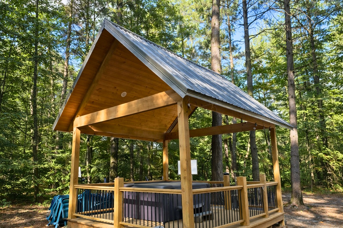 Unwind in the private covered hot tub, tucked away in the trees for the perfect relaxing soak