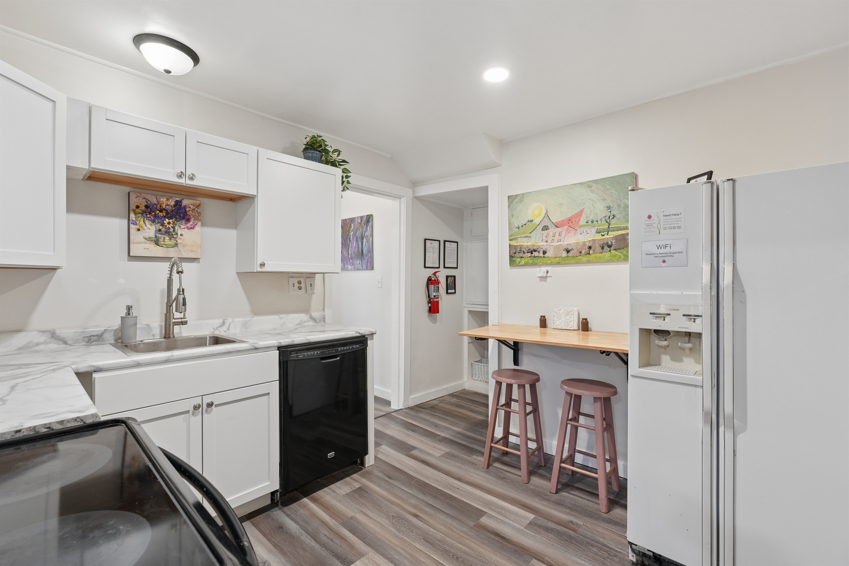 The downstairs kitchen includes a glass-top stove, dishwasher, folding wall table for two, and plenty of storage cabinets.