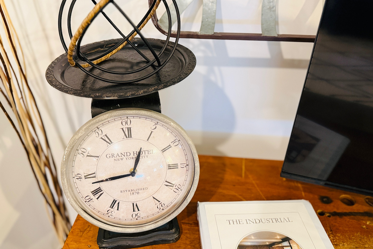 Industrial-style clock and metal sculpture complement the studio’s distinctive décor.