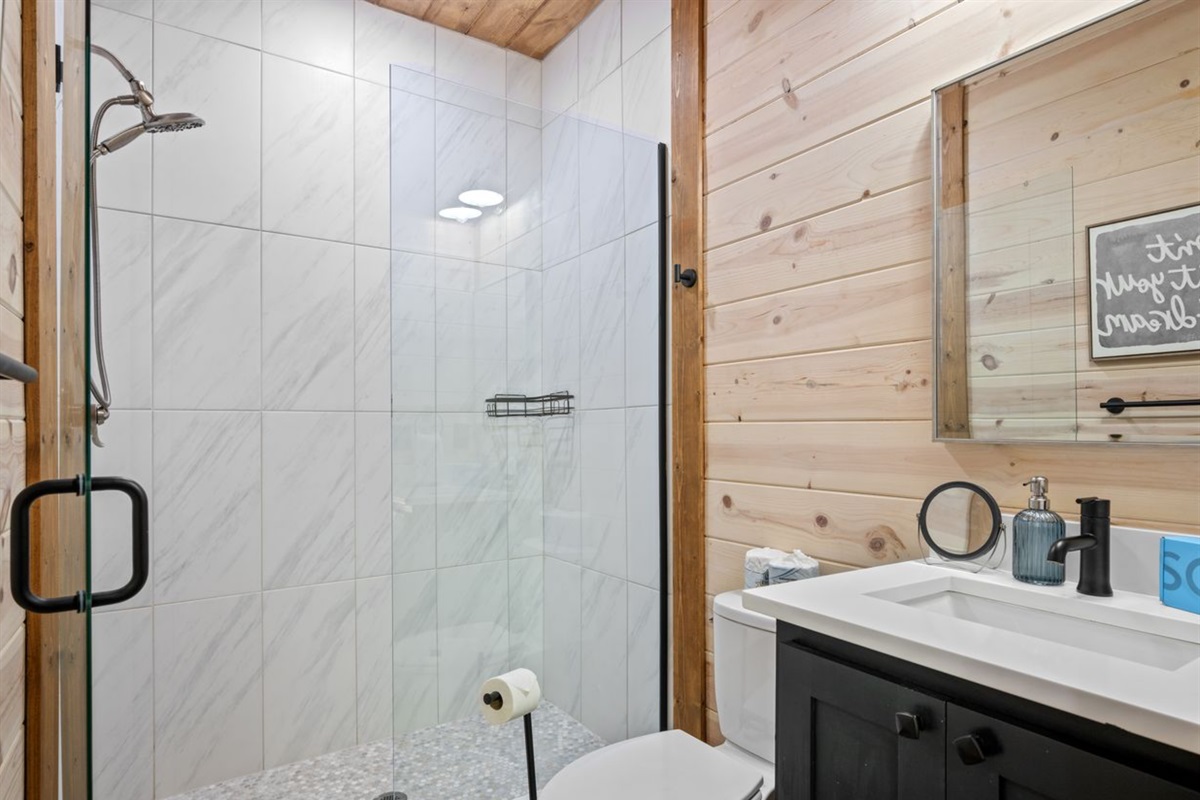 Spacious walk-in shower with sleek tile and glass enclosure.