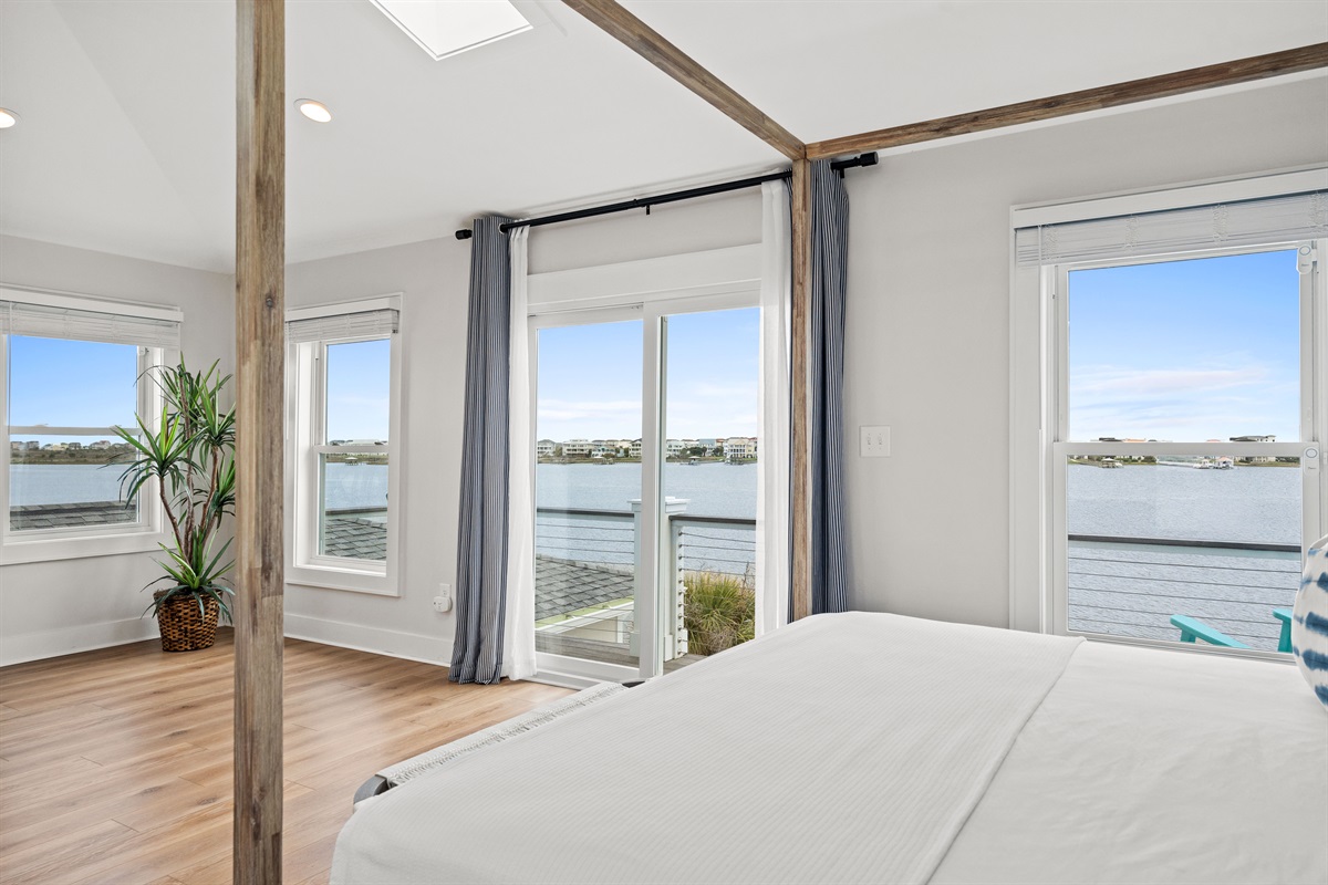 Spacious top-level retreat with panoramic water views surrounding the elegant king bed