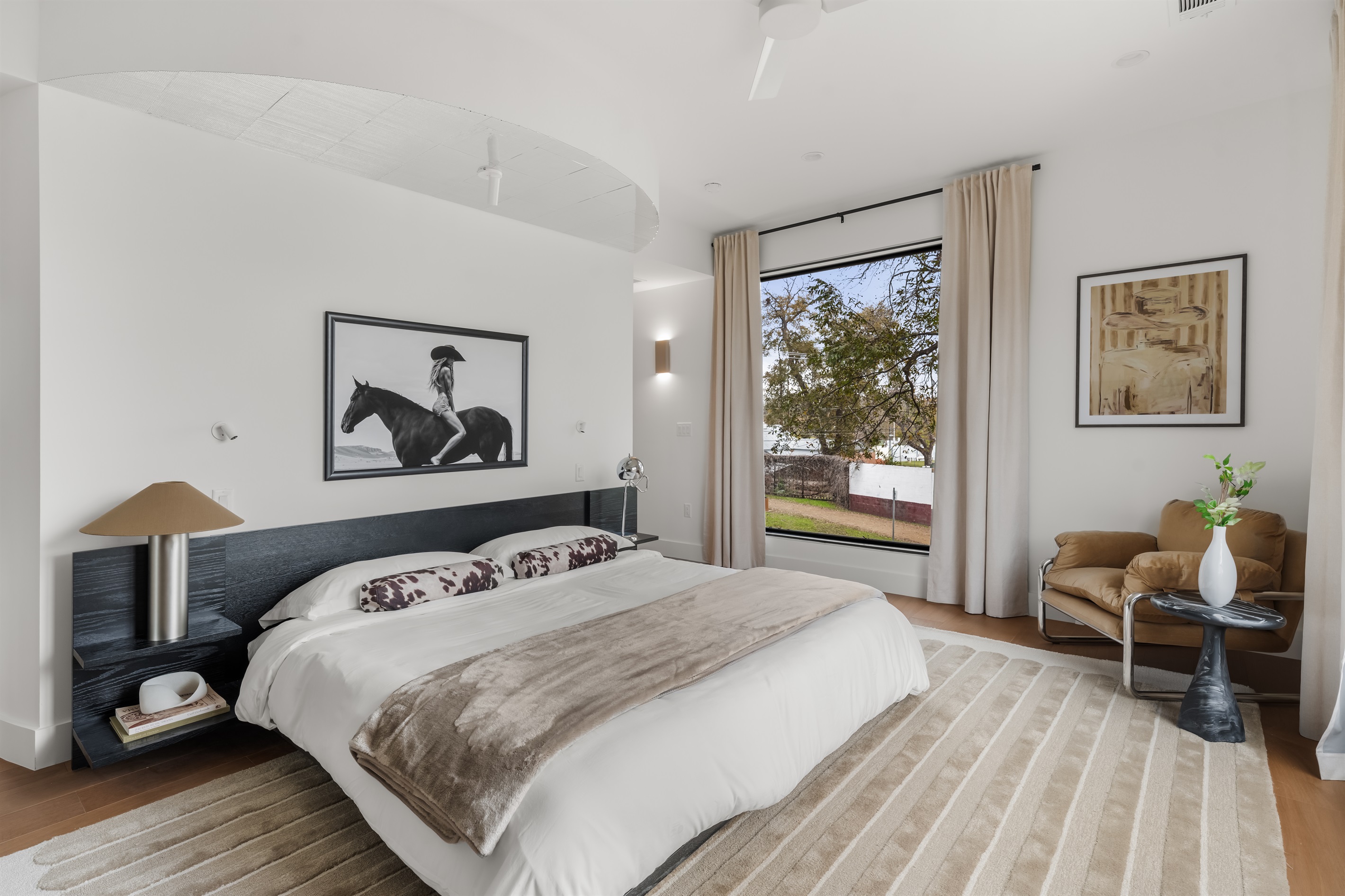 Bright and airy bedroom with elegant décor and large windows—offering comfort, style, and peaceful views.