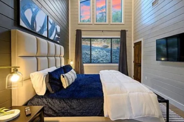 Spacious master bedroom featuring high ceilings and large windows.