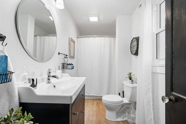 Main-floor full bathroom with a combination tub and shower and modern finishes.