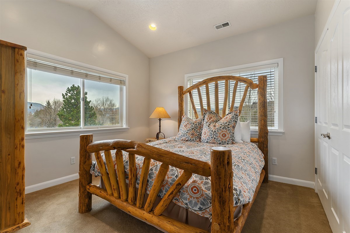 A cozy bedroom framed by scenic mountain views, where comfort and natural beauty come together effortlessly.