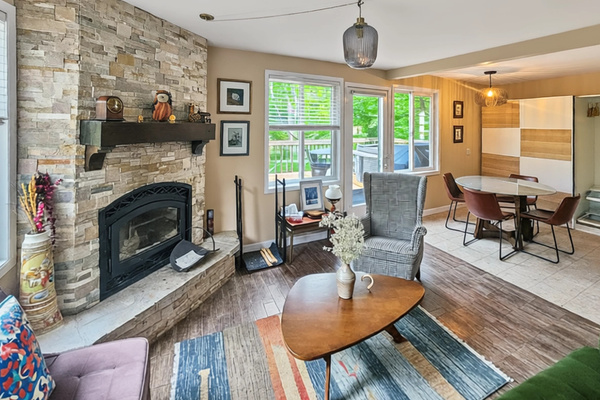 View across living room showing dining area and balcony access door