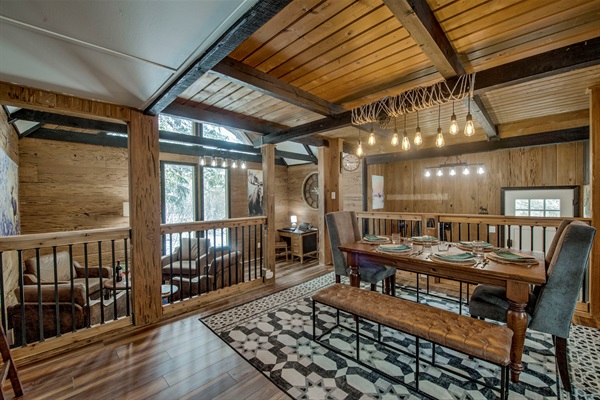 Gather in your warm dining room with exposed beams, soft lighting, and a table set for you and yours to savor meals and moments together.