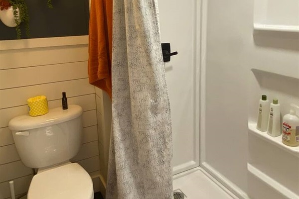 New bathroom with large walk-in shower, toilet, barn door closure and plenty of hooks for towels, robe and belongings. Large sink in laundry room with bright light to help you get ready!