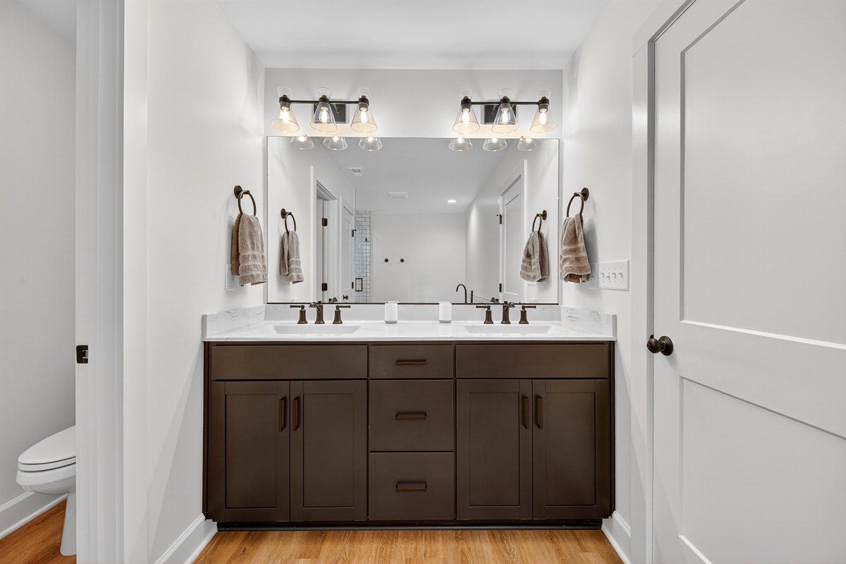 A luxurious escape featuring dual vanities, warm lighting, and sophisticated tile work—perfect for both daily routines and pampering moments.