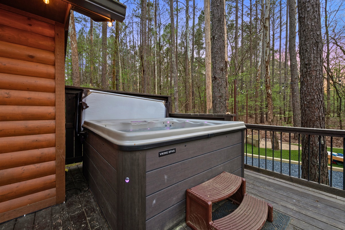 A private hot tub offers the perfect place to relax, surrounded by trees and the peaceful sounds of nature.
