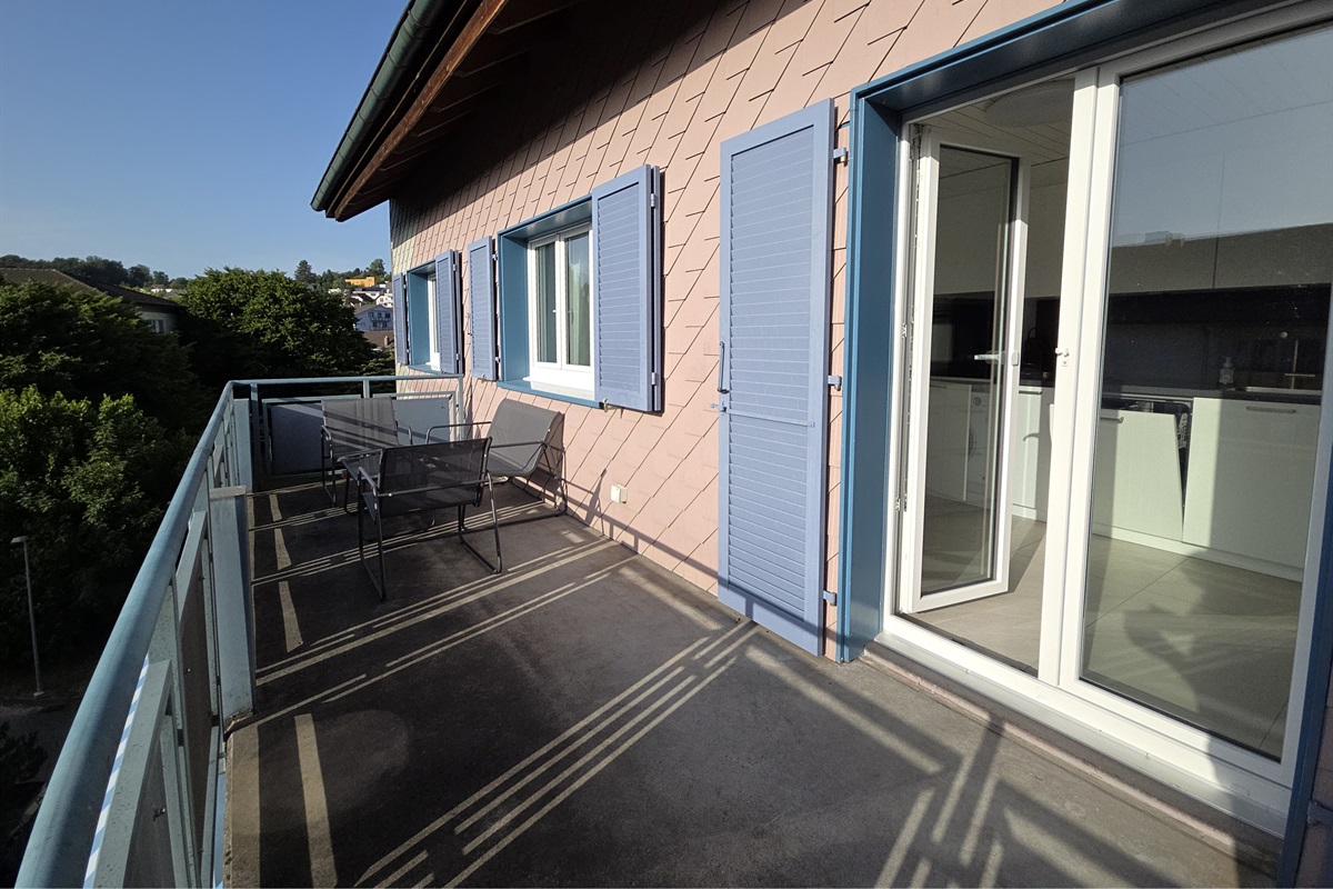 The large balcony is next to the kitchen and living room
