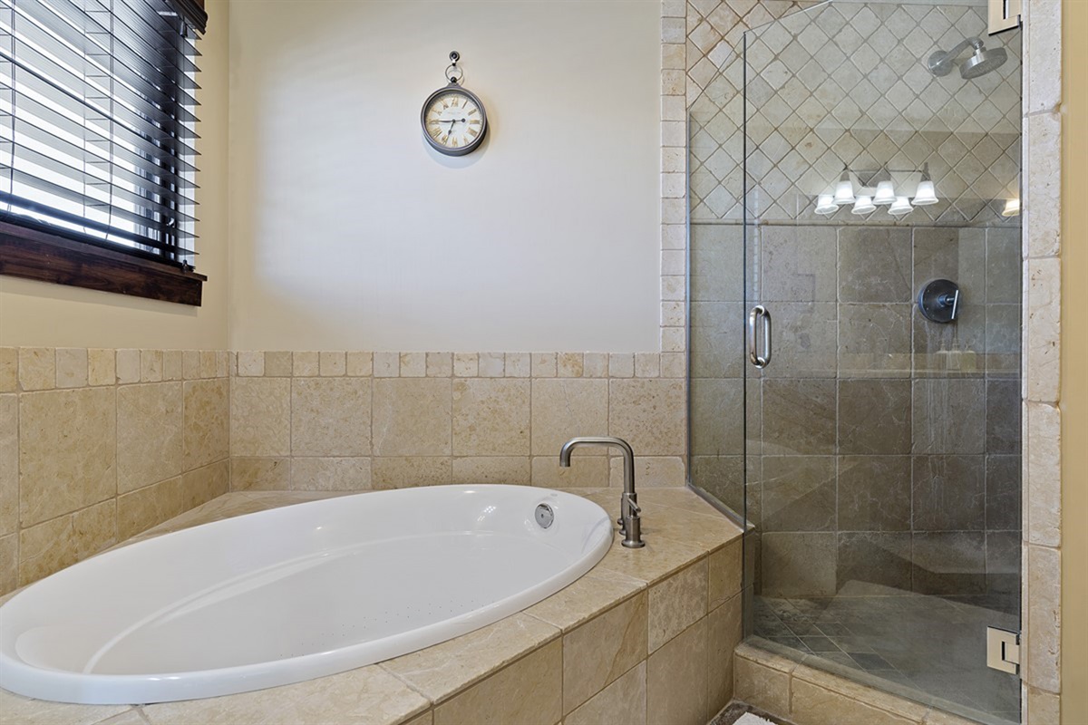 Indulge in a luxurious bath experience with a deep soaking tub and walk-in shower, beautifully finished for ultimate relaxation.