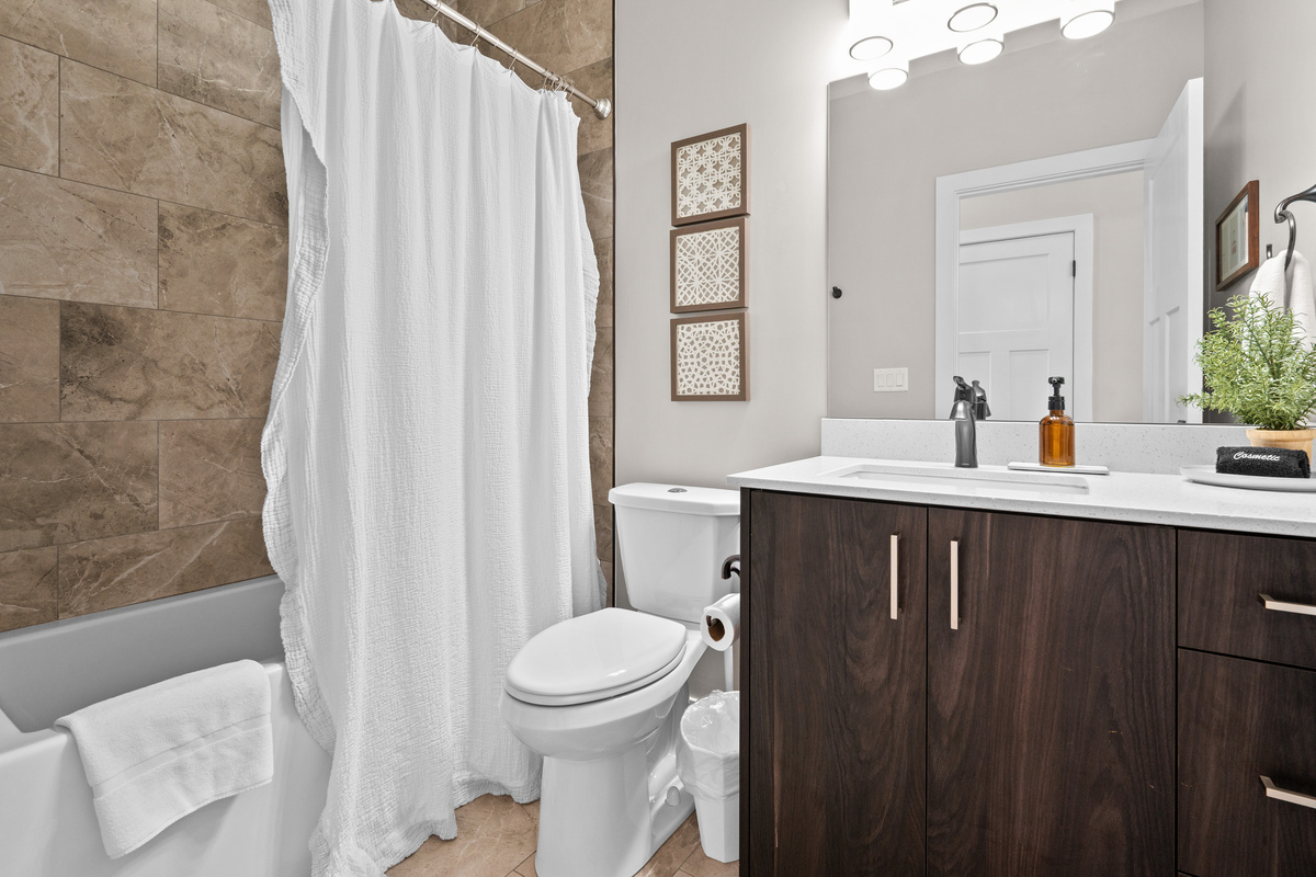 Full bathroom with a tub/shower combination, spacious vanity, and modern finishes for everyday comfort.