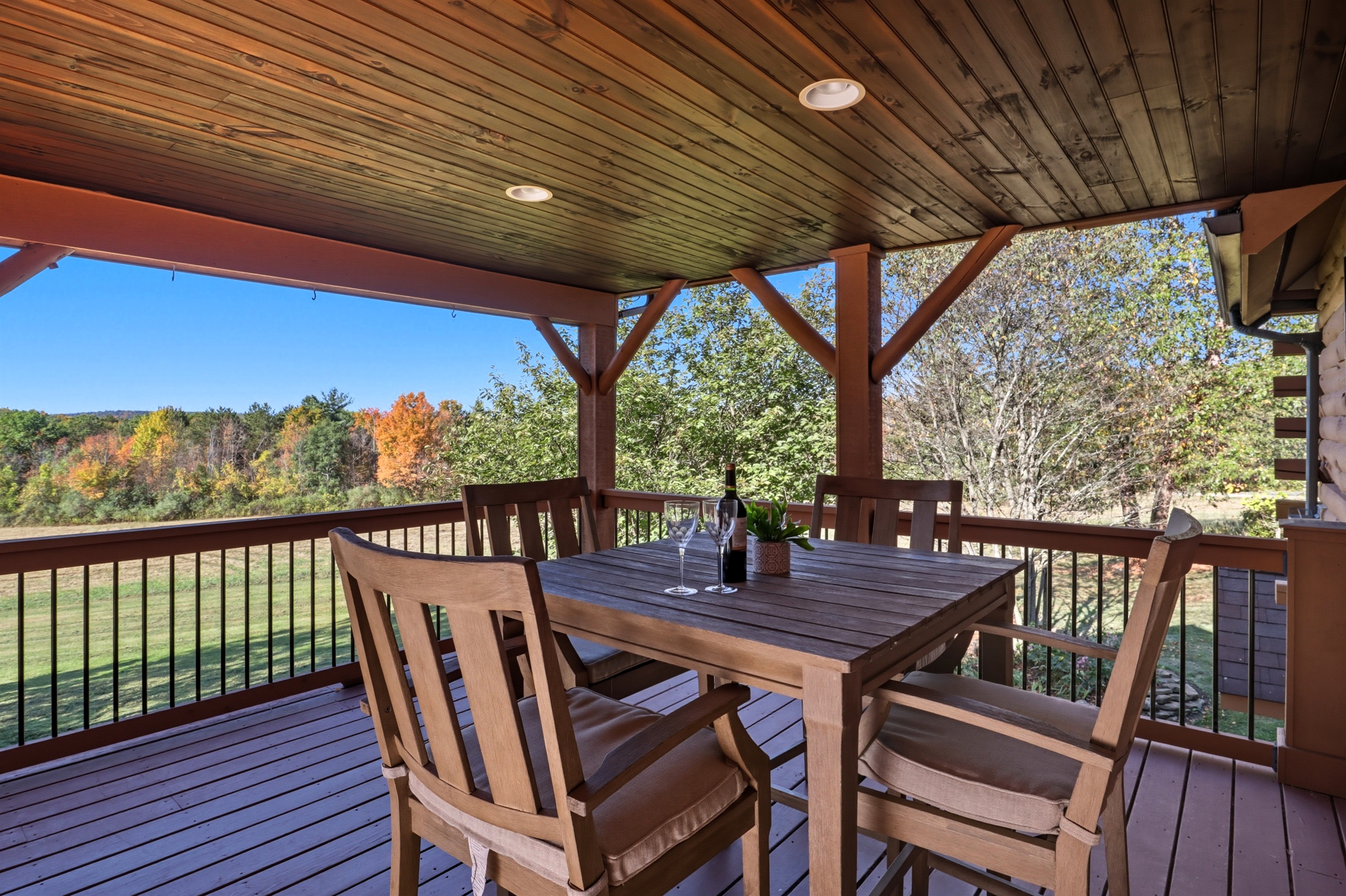 Outdoor dining under a rustic wood-beam pergola.