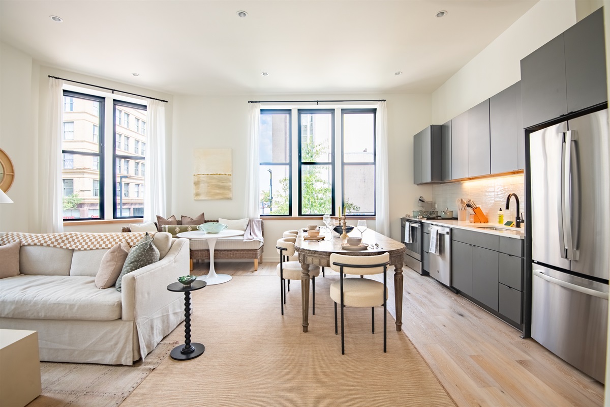 Bright open-concept living and dining space with large windows and modern finishes