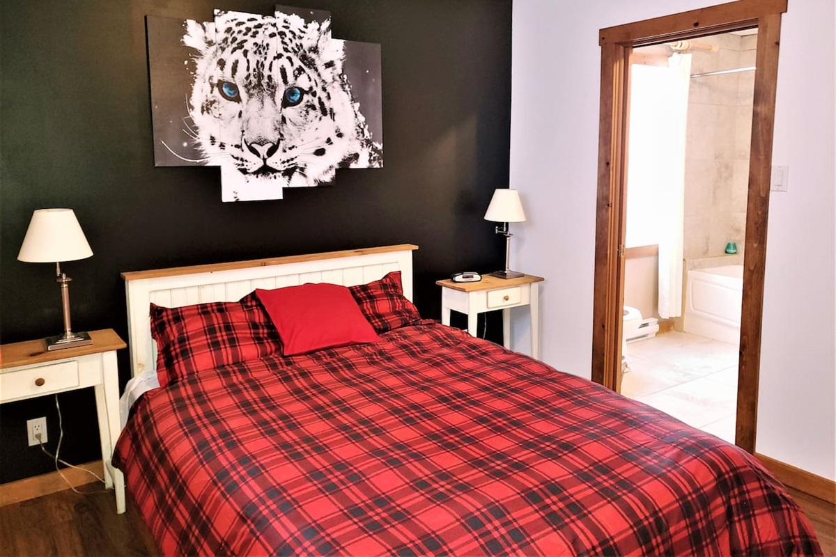 Chambre #1 au rez-de-chaussée avec un lit queen et une salle de bain.