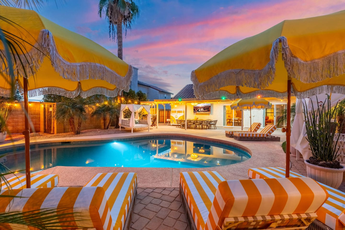 A cozy umbrella nook with lounge chairs offers a quiet corner beside the pool.
