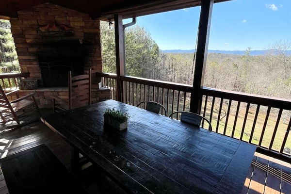 Outdoor wood-burning fireplace and outdoor dining table on the back deck with mountain views!