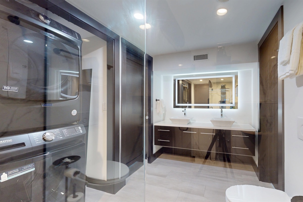 Lower level Full Bathroom, double vanity, walk-in shower, and stacked washer and dryer.
