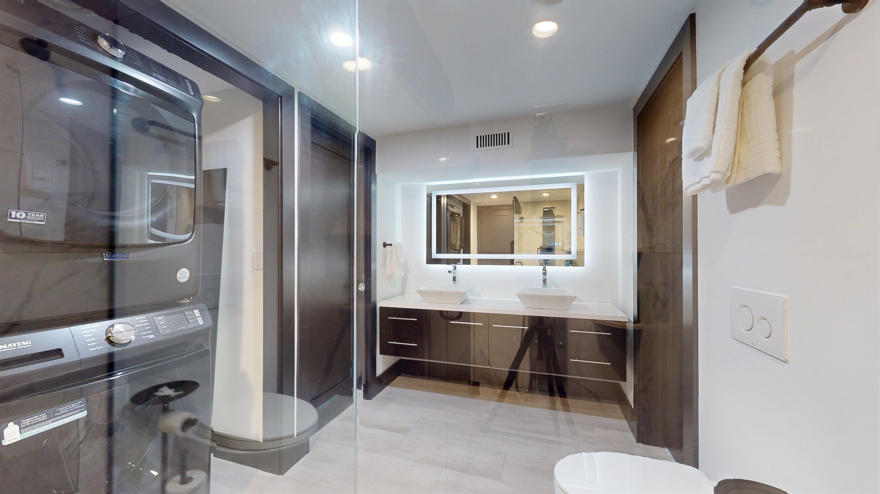 Lower level Full Bathroom, double vanity, walk-in shower, and stacked washer and dryer.