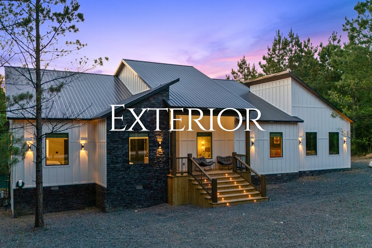 Warm exterior lighting and modern farmhouse-inspired design give the cabin incredible curb appeal that feels especially inviting at dusk.