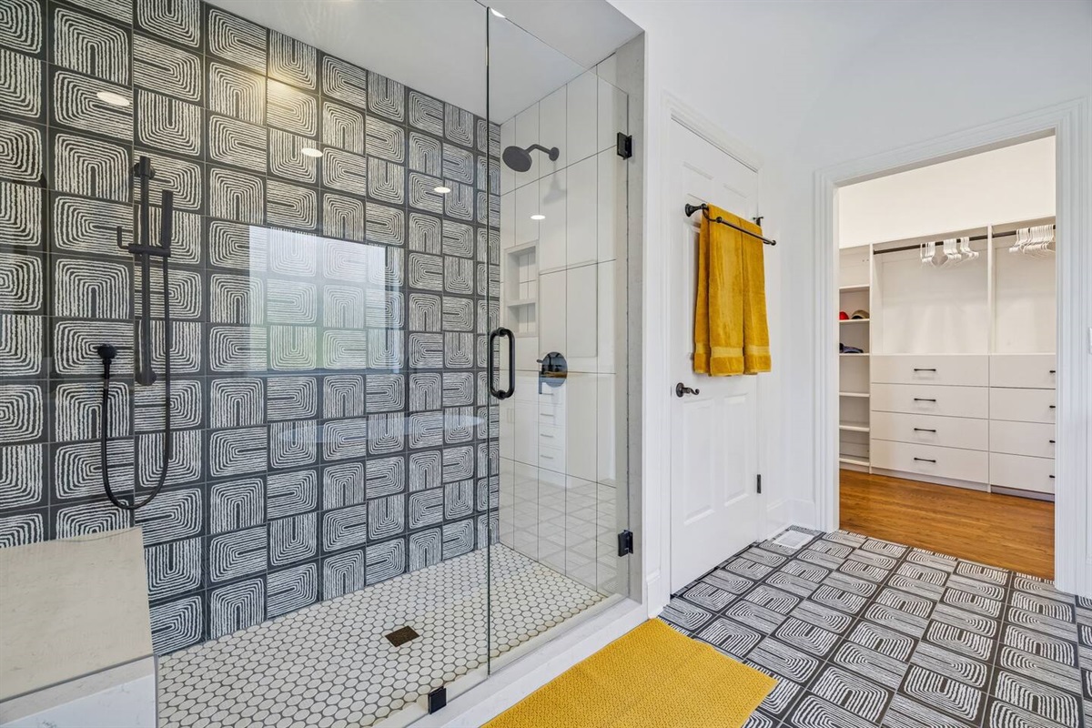 Huge shower with hand held, stone mitered bench and niche.