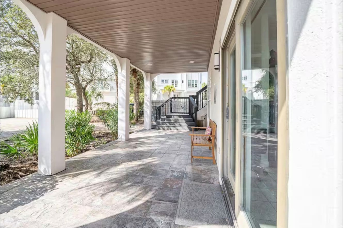 Covered ground-level patio and shaded walkway offering seamless indoor-outdoor access through large sliding glass doorS