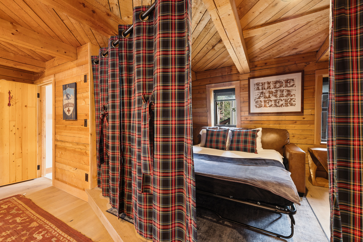 Upper level loft/multi-function living space. In this photo, the partition is partially closed, creating privacy for guests using the Queen sleeper sofa seating area as a bedroom. Bathroom is on far left. 