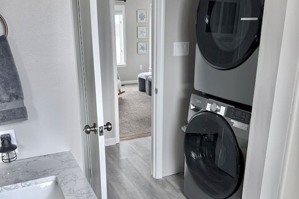 The laundry area features a modern, stacked washer and dryer unit.