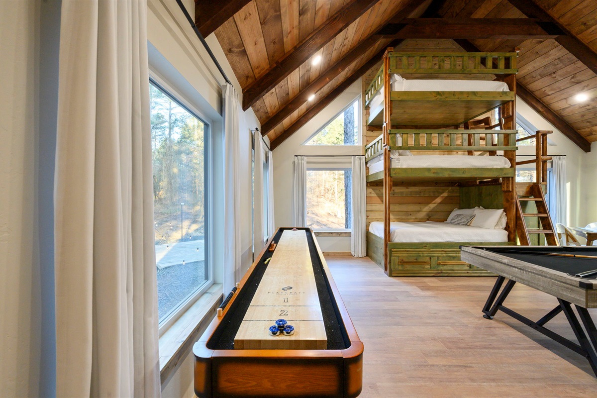 Challenge your crew to shuffleboard while enjoying forest views 🌲