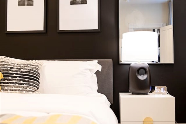 A cozy king-sized bed with soft, inviting linens, positioned beside a large window that lets in natural light, offering a peaceful and serene atmosphere.