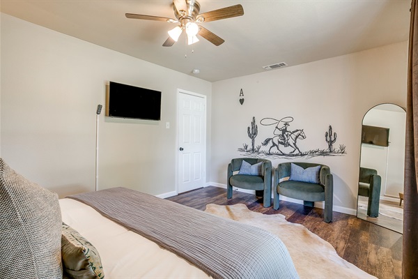Cowboy-themed bedroom with desk space, smart TV, and ranch-style charm