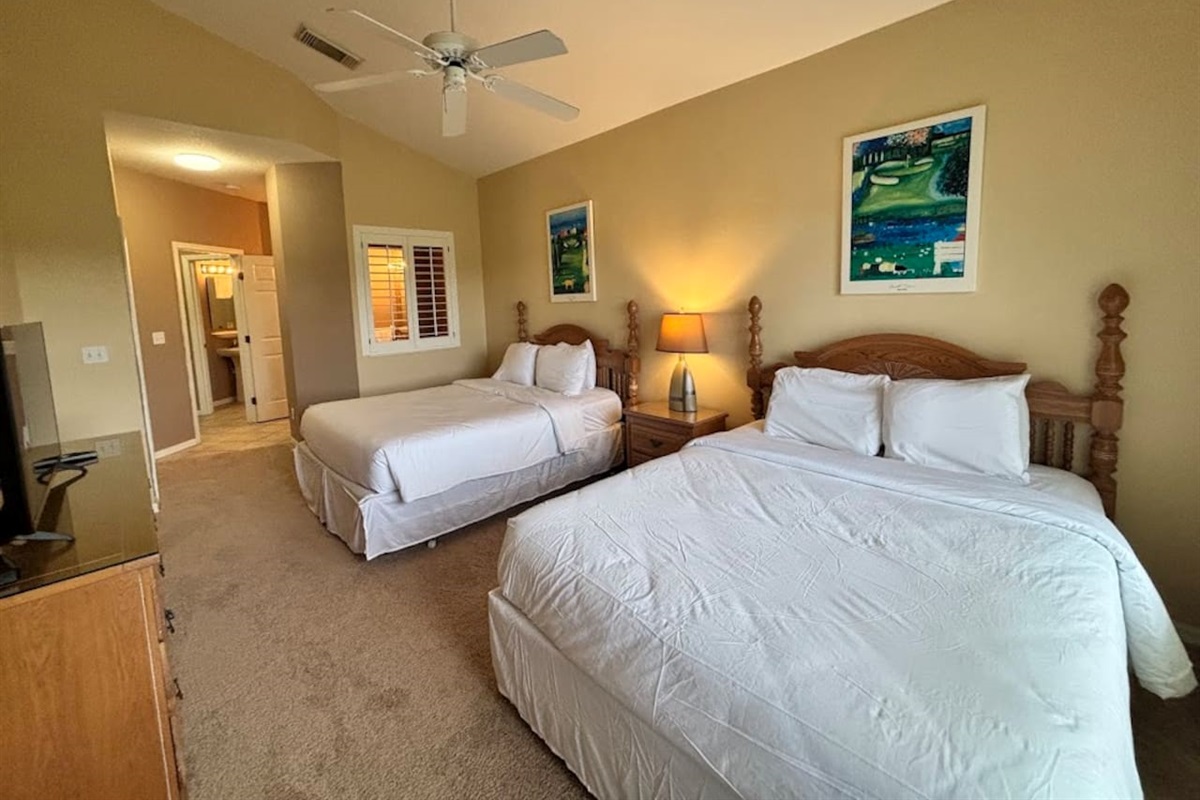 Comfortable bedroom with two beds, ceiling fan, bedside lighting, and a relaxing layout.