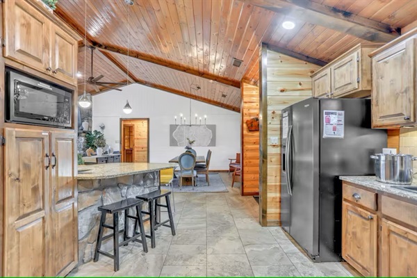 Open kitchen with bar seating and sightlines into dining and living areas.