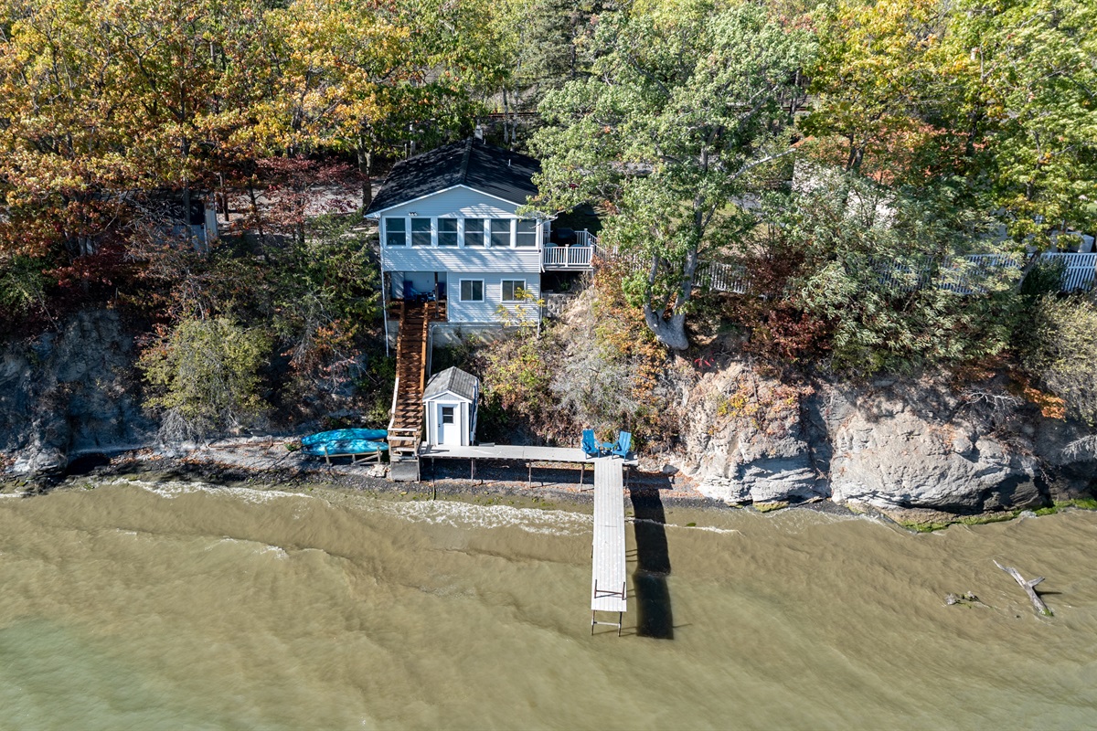 Iconic blue lake house perched above the dock—unmatched water views from every angle