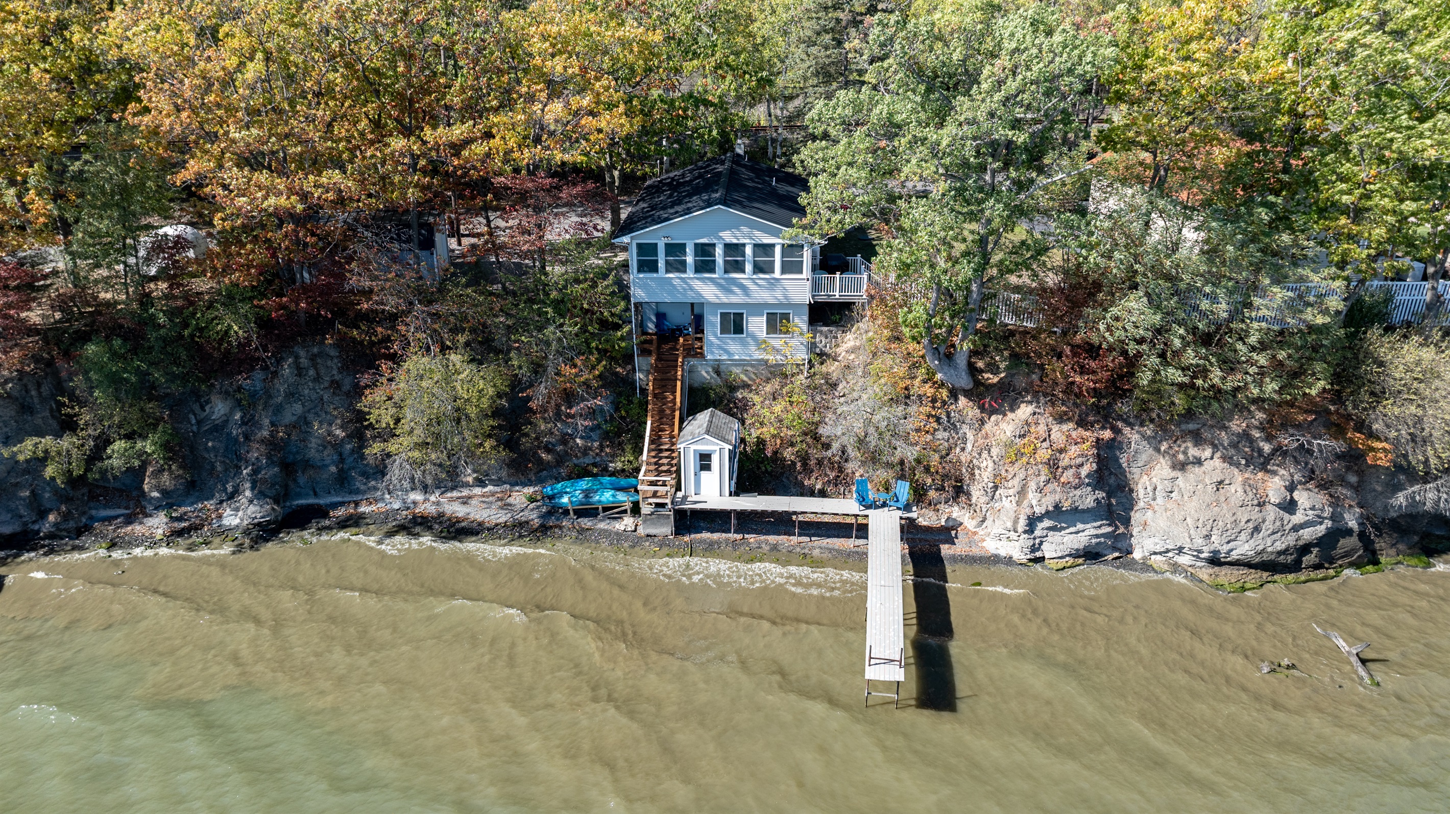 Iconic blue lake house perched above the dock—unmatched water views from every angle