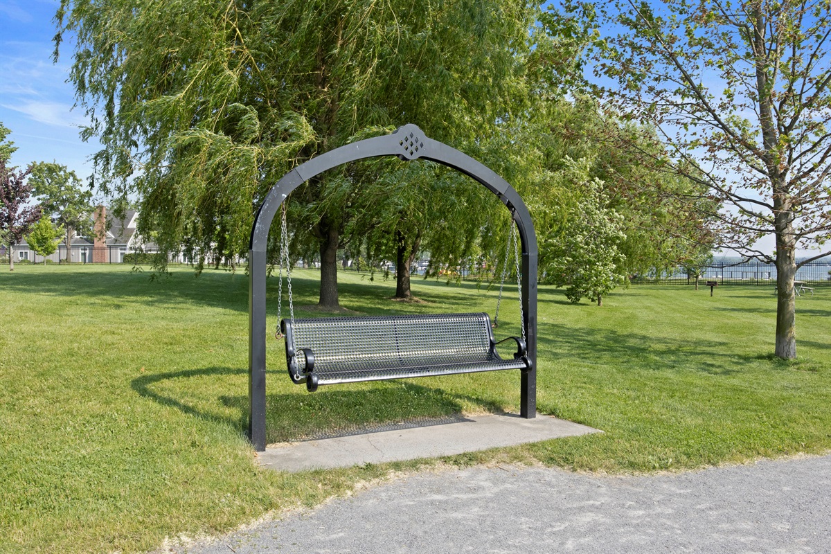 Enjoy quiet moments on this shaded swing surrounded by green open space