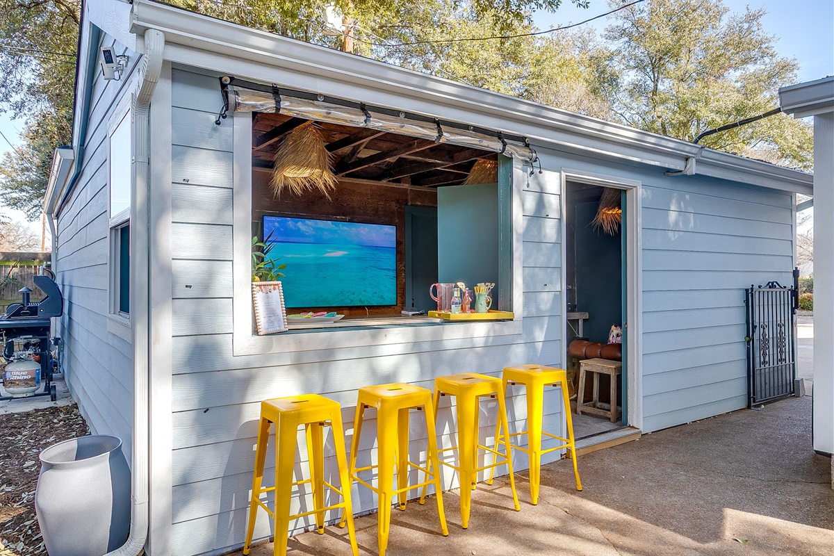 Outdoor bar with service window, lounge seating and TV