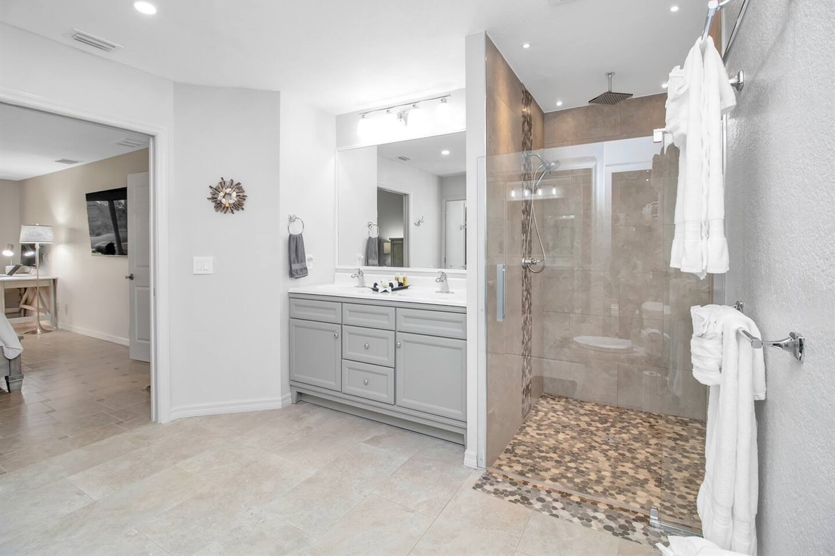 Spacious bathroom with a oversized walk-in shower, double sink, & ample closet space. 